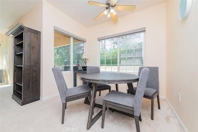 dining room with baseboards, ceiling fan, and light colored carpet