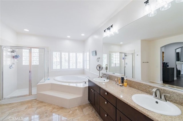 bathroom with a wealth of natural light, a sink, and a bath