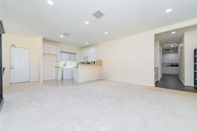 unfurnished living room featuring light carpet, visible vents, and recessed lighting