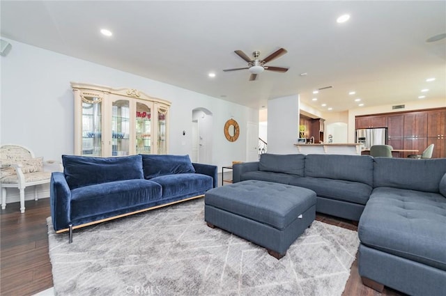 living area with arched walkways, recessed lighting, visible vents, ceiling fan, and wood finished floors