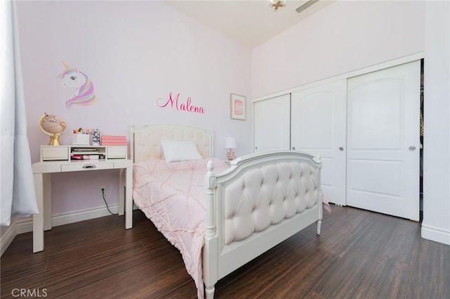 bedroom featuring dark wood-type flooring, a closet, visible vents, and baseboards