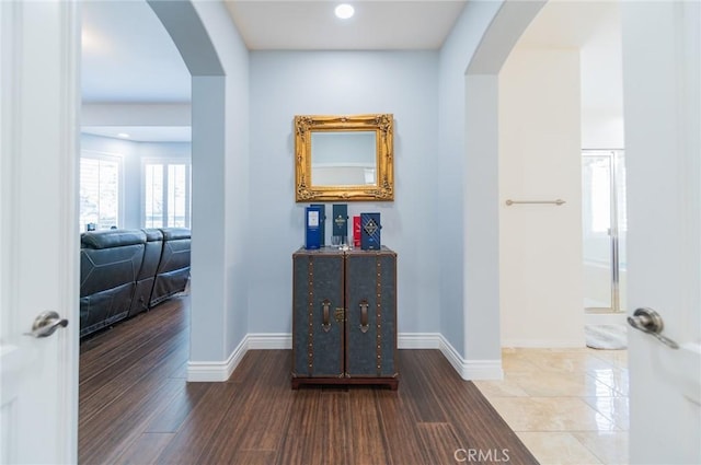 hall with arched walkways, recessed lighting, wood finished floors, and baseboards