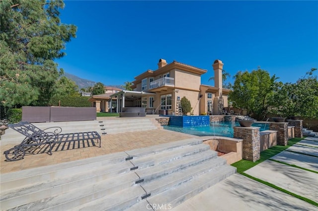 outdoor pool with a hot tub and a patio