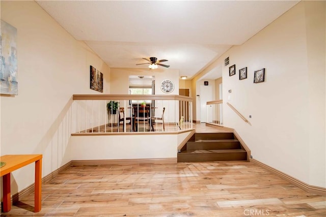 stairway featuring visible vents, wood finished floors, and a ceiling fan