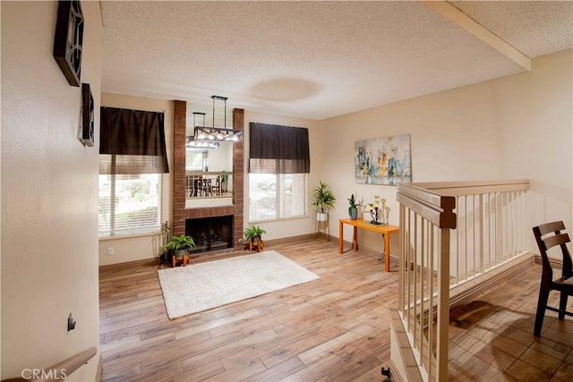 living room featuring a textured ceiling, a healthy amount of sunlight, and wood finished floors