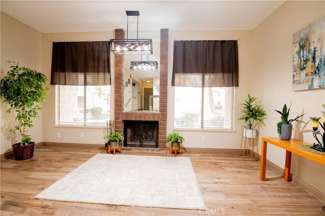 living room with a fireplace, plenty of natural light, and wood finished floors