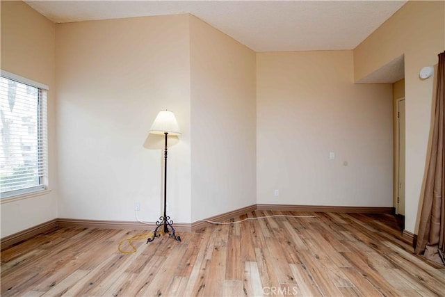 empty room featuring light wood-style flooring and baseboards