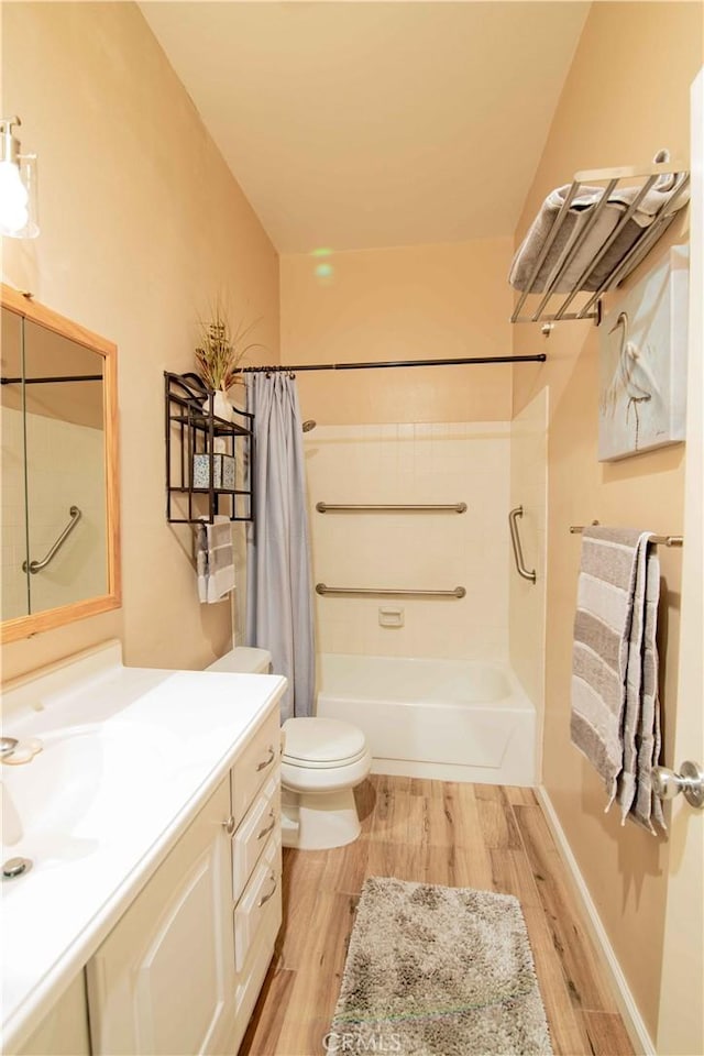 bathroom with vanity, toilet, wood finished floors, and shower / bath combo with shower curtain