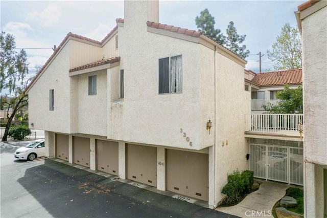 exterior space featuring stucco siding and a tiled roof