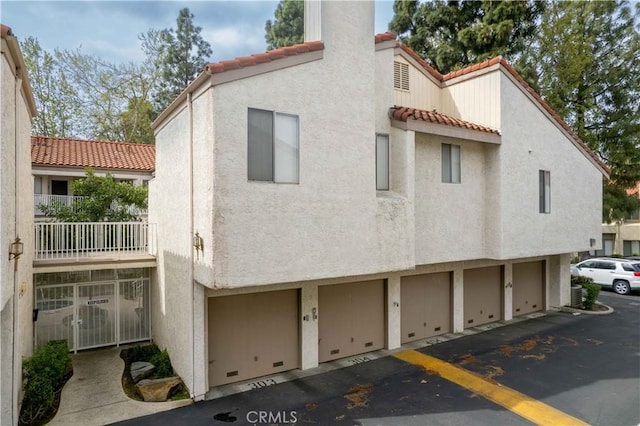 view of home's exterior with a tile roof and stucco siding