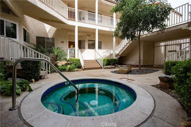 view of pool featuring stairway and an in ground hot tub