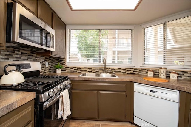 kitchen with decorative backsplash, appliances with stainless steel finishes, and a sink