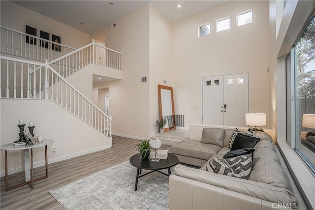 living area with visible vents, baseboards, wood finished floors, stairs, and recessed lighting