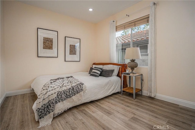 bedroom with recessed lighting, wood finished floors, and baseboards