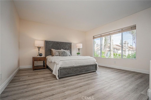 bedroom with baseboards and wood finished floors