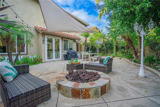 view of patio / terrace featuring a grill, a fire pit, and french doors