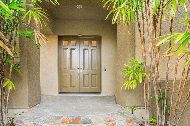 doorway to property featuring stucco siding