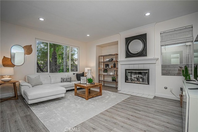 living area with a fireplace, wood finished floors, and recessed lighting