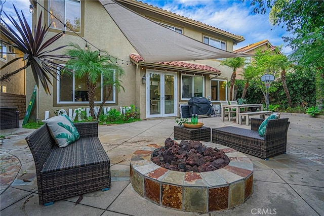 view of patio / terrace featuring french doors, area for grilling, and an outdoor living space with a fire pit