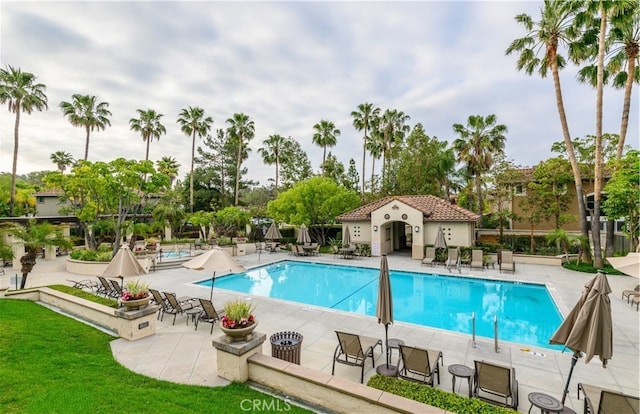 community pool with a patio area and fence