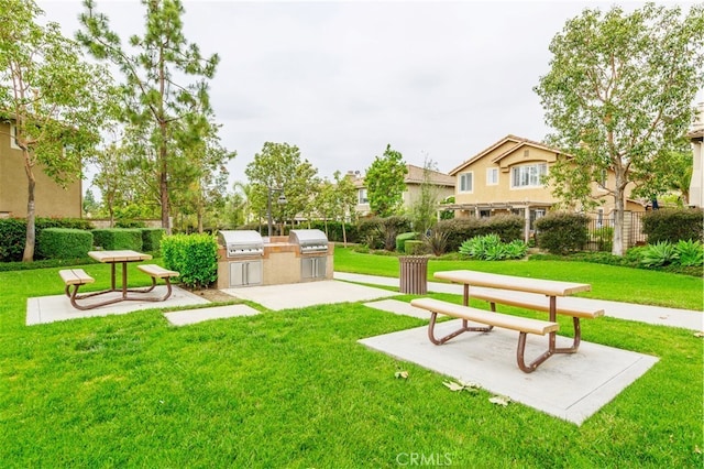 view of home's community with a patio area, a yard, and area for grilling