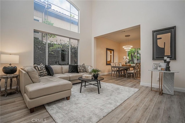 living area with plenty of natural light, baseboards, and wood finished floors