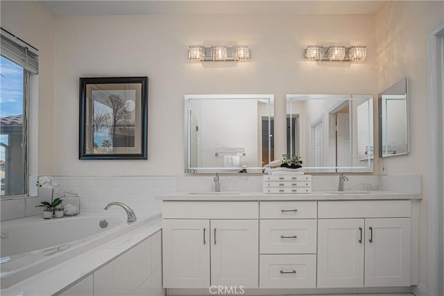 full bath with double vanity, a garden tub, and a sink