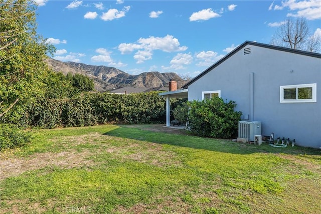 view of yard featuring central AC unit and a mountain view