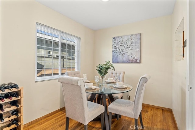 dining area featuring light wood-style flooring and baseboards