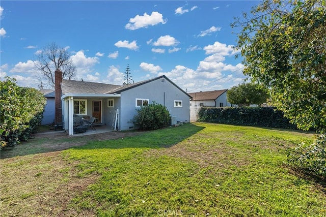 rear view of house with a yard, a patio, stucco siding, crawl space, and fence