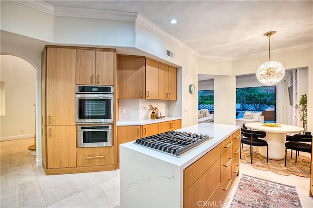 kitchen featuring arched walkways, stainless steel appliances, visible vents, light countertops, and ornamental molding