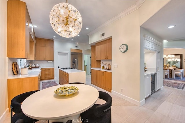 dining room featuring an inviting chandelier, ornamental molding, recessed lighting, beverage cooler, and baseboards