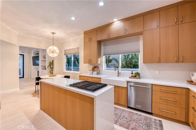 kitchen with ornamental molding, light countertops, appliances with stainless steel finishes, a sink, and hanging light fixtures