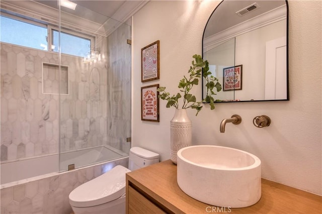 full bath featuring toilet, shower / bath combination with glass door, vanity, and visible vents