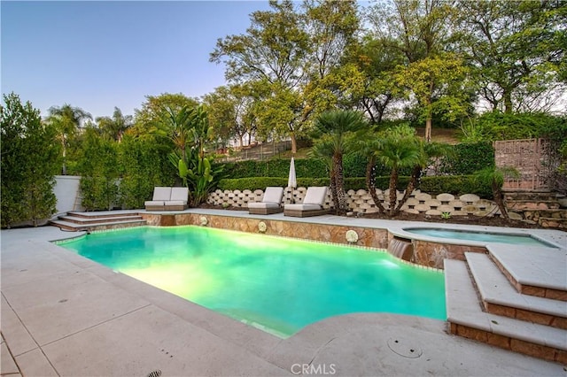 outdoor pool with a patio area, a fenced backyard, and an in ground hot tub