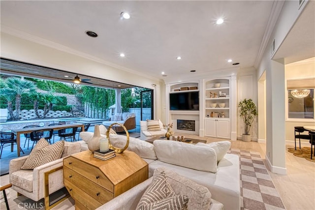 living room with ornamental molding, built in shelves, recessed lighting, and baseboards