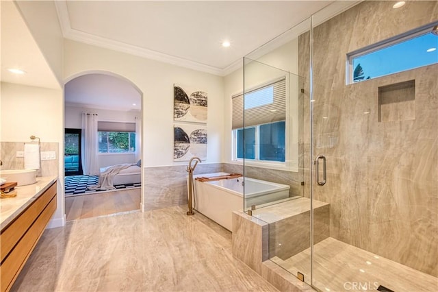 ensuite bathroom with crown molding, a soaking tub, a stall shower, connected bathroom, and vanity