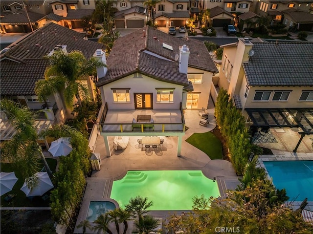 rear view of property with a tiled roof, a residential view, and stucco siding