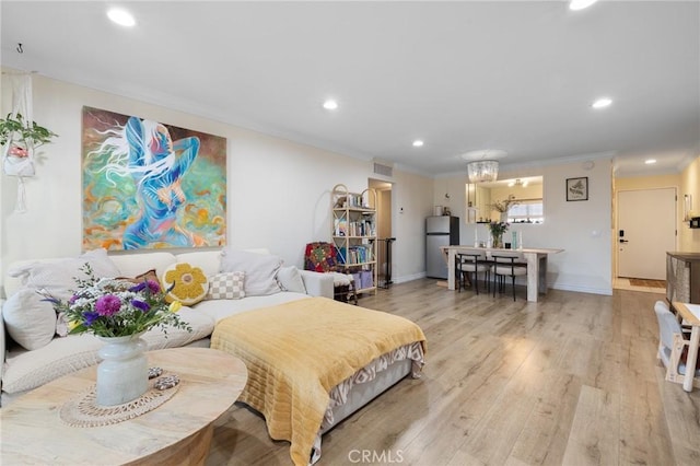 bedroom with recessed lighting, visible vents, light wood-style flooring, ornamental molding, and freestanding refrigerator