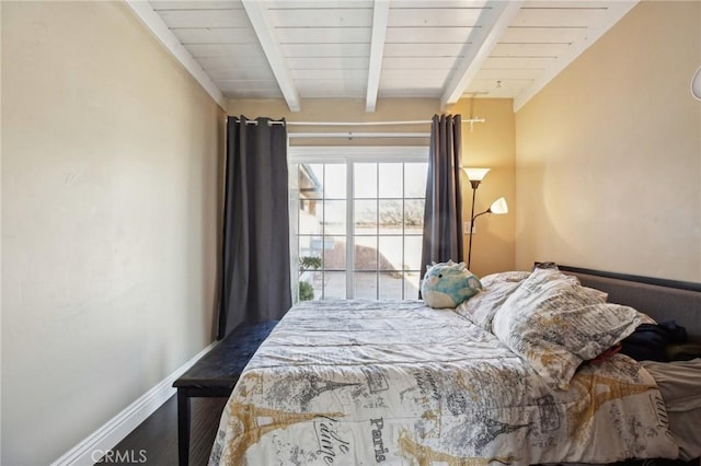 bedroom with dark wood-style floors, beamed ceiling, and baseboards