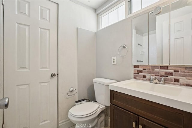 bathroom featuring toilet, decorative backsplash, and vanity