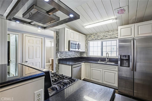 kitchen with appliances with stainless steel finishes, dark countertops, and white cabinetry