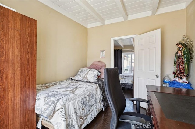 bedroom featuring dark wood-style floors and beam ceiling