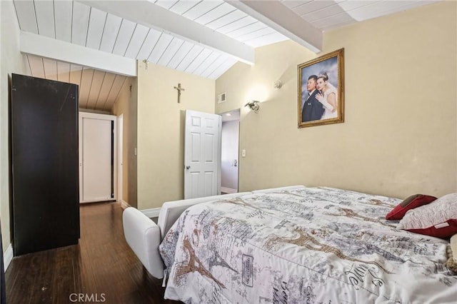 bedroom with dark wood-type flooring, visible vents, lofted ceiling with beams, and baseboards