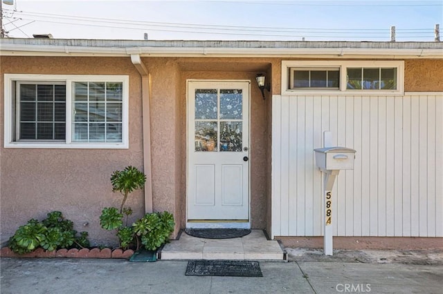 entrance to property featuring stucco siding