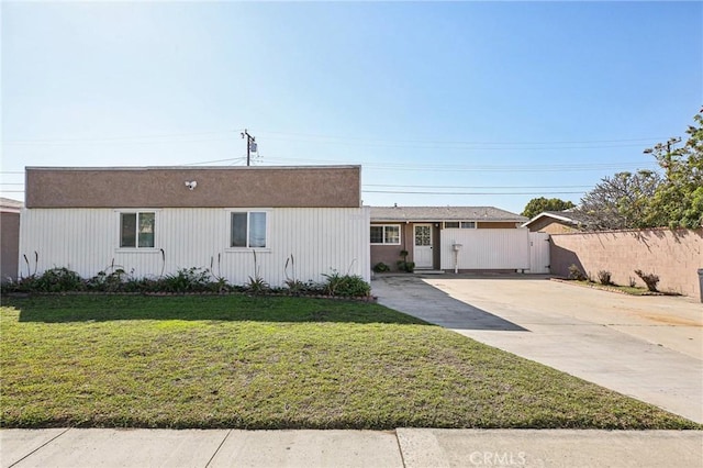 view of front facade with driveway, a front yard, fence, and a gate