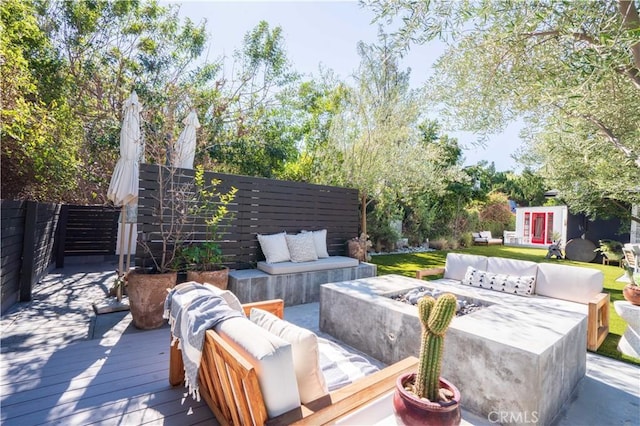 wooden deck featuring an outbuilding and an outdoor living space with a fire pit