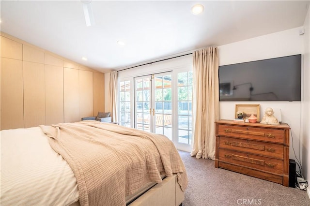 bedroom featuring lofted ceiling, access to outside, and light colored carpet