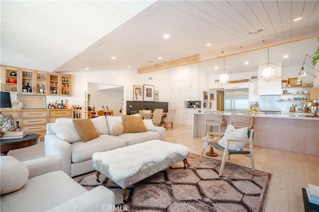 living room with lofted ceiling with beams, recessed lighting, visible vents, and light wood-style floors