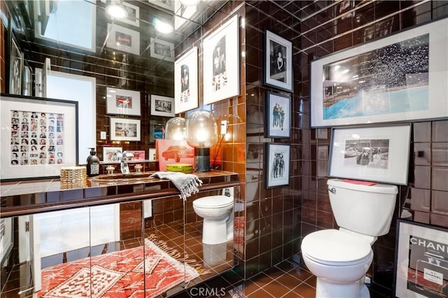 half bathroom featuring vanity, tile patterned flooring, toilet, and tile walls